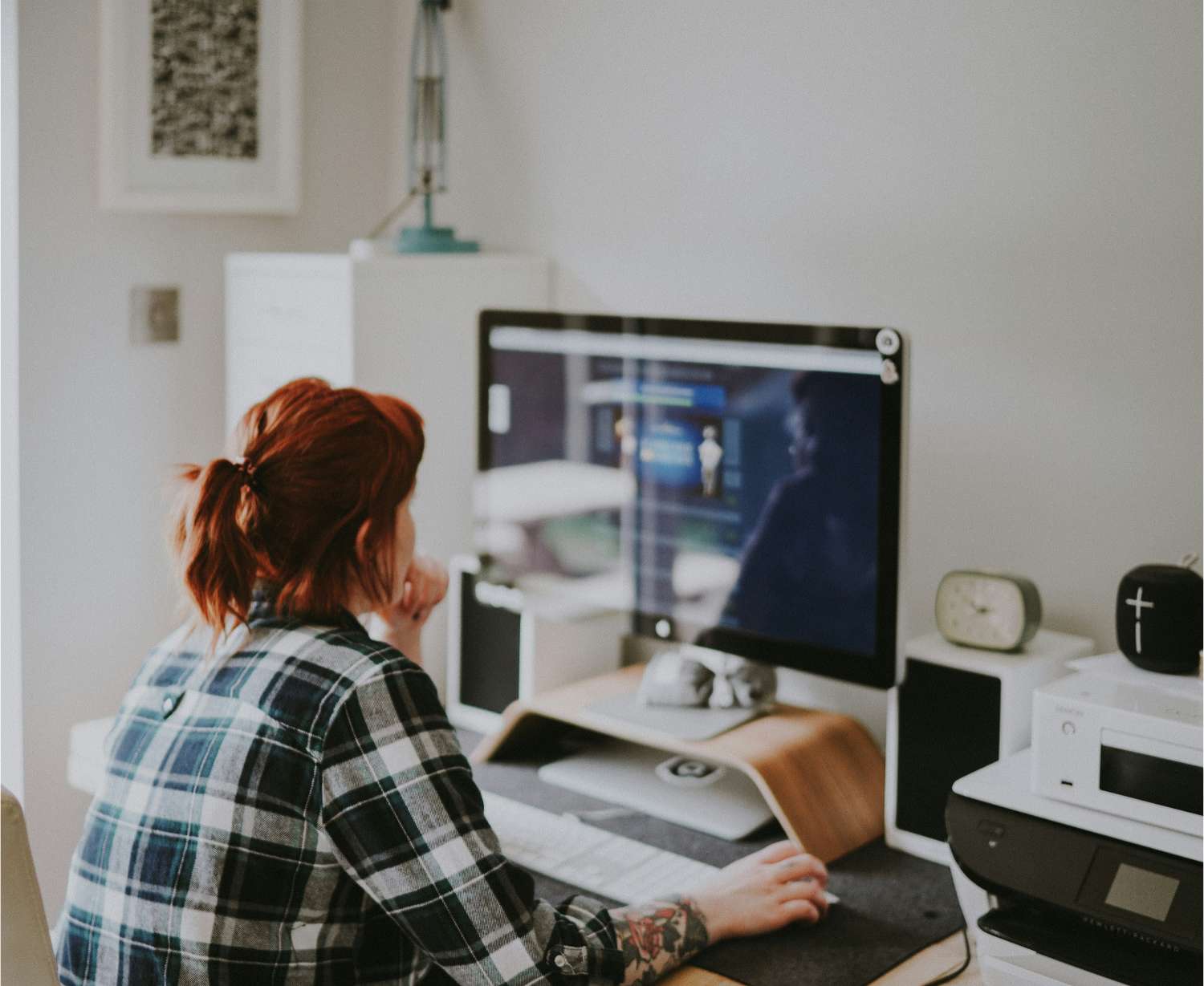Woman sitting at a desk looking at her computer screen.